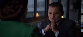 Movie still from “Ratched” (2020), created by Evan Romansky – A man in a suit and tie looking at another man in a green shirt; Close Up shot, Over the shoulder angle