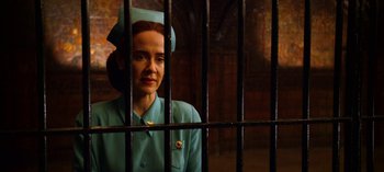 Movie still from “Ratched” (2020), created by Evan Romansky – A woman in a blue uniform behind a metal fence; Close Up shot, Low angle