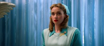 Movie still from “Ratched” (2020), created by Evan Romansky – A woman in a blue and white dress with a blue bow; Close Up shot, Low angle