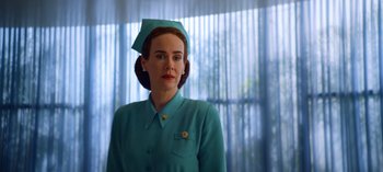 Movie still from “Ratched” (2020), created by Evan Romansky – A woman in a blue dress with a hat on her head; Medium shot, Low angle