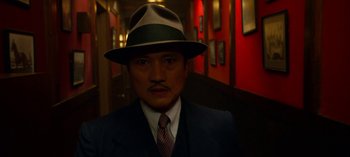 Movie still from “Ratched” (2020), created by Evan Romansky – A man wearing a suit and a hat in a hallway; Close Up shot, Low angle