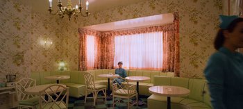 Movie still from “Ratched” (2020), created by Evan Romansky – A woman sitting at a table in a restaurant; Wide shot, High angle