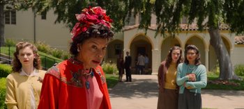 Movie still from “Ratched” (2020), created by Evan Romansky – An older woman wearing a red jacket and a red hat; Medium shot, Over the shoulder angle