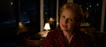Movie still from “Ratched” (2020), created by Evan Romansky – An older woman wearing a red and white checkered jacket; Close Up shot, Over the shoulder angle