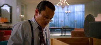 Movie still from “Ratched” (2020), created by Evan Romansky – A man with glasses and a tie is looking down; Medium shot, Low angle