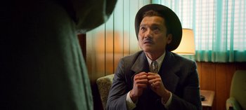 Movie still from “Ratched” (2020), created by Evan Romansky – A man in a suit and a hat is looking at a woman; Close Up shot, Low angle