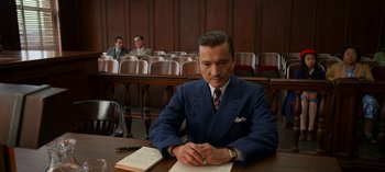 Movie still from “Ratched” (2020), created by Evan Romansky – A man sitting at a table in a courtroom; Medium shot, Low angle