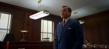 Movie still from “Ratched” (2020), created by Evan Romansky – A man wearing a suit and tie in a courtroom; Medium shot, Low angle