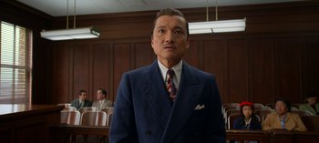 Movie still from “Ratched” (2020), created by Evan Romansky – A man in a suit and tie standing in a courtroom; Medium shot, Low angle