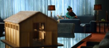 Movie still from “Ratched” (2020), created by Evan Romansky – A man sitting on a couch in a living room; Wide shot, Over the shoulder angle
