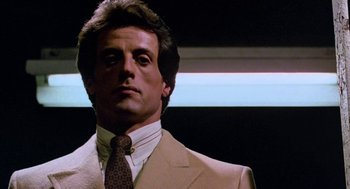 Movie still from “Rocky III” (1982), directed by Sylvester Stallone – A person wearing a suit and a tie; Close Up shot, Low angle
