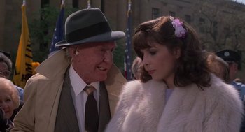 Movie still from “Rocky III” (1982), directed by Sylvester Stallone – An older man and a young woman standing next to each other; Close Up shot, Over the shoulder angle