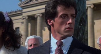 Movie still from “Rocky III” (1982), directed by Sylvester Stallone – A man in a suit and tie; Close Up shot, Low angle