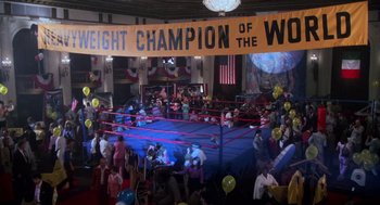 Movie still from “Rocky III” (1982), directed by Sylvester Stallone – A crowd of people are in a boxing ring; Extreme Wide shot, High angle