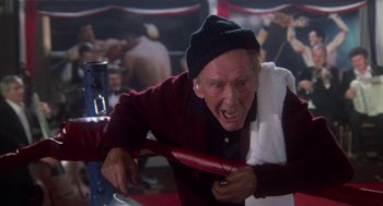 Movie still from “Rocky III” (1982), directed by Sylvester Stallone – An old man is holding a towel over his face; Medium shot, Low angle