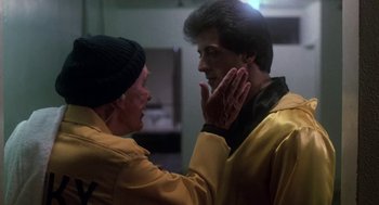 Movie still from “Rocky III” (1982), directed by Sylvester Stallone – A man and a woman talking to each other; Close Up shot, Over the shoulder angle