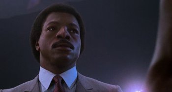 Movie still from “Rocky III” (1982), directed by Sylvester Stallone – A person wearing a suit and tie; Close Up shot, Low angle