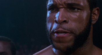 Movie still from “Rocky III” (1982), directed by Sylvester Stallone – A person with a beard; Extreme Close Up shot, Low angle