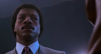 Movie still from “Rocky III” (1982), directed by Sylvester Stallone – A person wearing a suit and tie; Close Up shot, Low angle