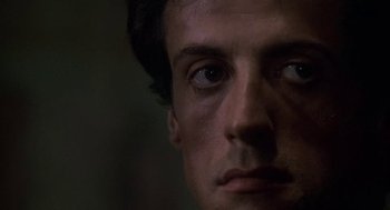 Movie still from “Rocky III” (1982), directed by Sylvester Stallone – A man's face in the dark; Close Up shot, Low angle