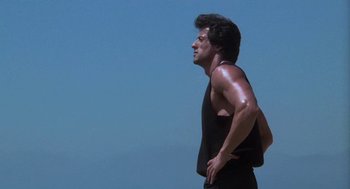 Movie still from “Rocky III” (1982), directed by Sylvester Stallone – A person standing in the sun; Medium shot, Low angle