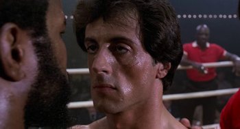 Movie still from “Rocky III” (1982), directed by Sylvester Stallone – A person in a boxing ring; Close Up shot, Over the shoulder angle