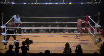Movie still from “Rocky III” (1982), directed by Sylvester Stallone – Spectators watching a professional boxing match in a ring; Wide shot, High angle