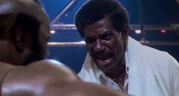 Movie still from “Rocky III” (1982), directed by Sylvester Stallone – An older man is yelling at another man in a boxing ring; Close Up shot, Low angle
