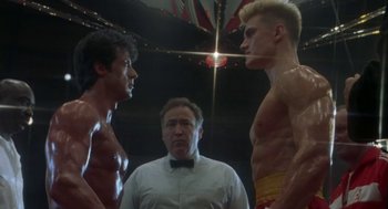Movie still from “Rocky V” (1990), directed by John G. Avildsen – Two boxers face each other in front of a referee; Medium shot, Low angle