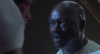 Movie still from “Rocky V” (1990), directed by John G. Avildsen – A man with a bald head talking to another man; Close Up shot, Low angle