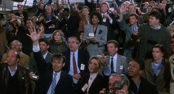 Movie still from “Rocky V” (1990), directed by John G. Avildsen – A group of people sitting in a room with their hands raised; Medium shot, High angle