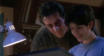 Movie still from “Rocky V” (1990), directed by John G. Avildsen – A man and a boy looking at a computer screen; Close Up shot, Over the shoulder angle