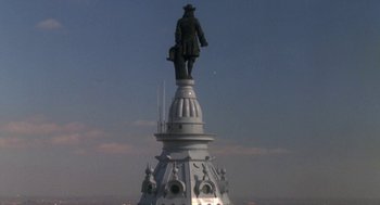 Movie still from “Rocky V” (1990), directed by John G. Avildsen – A statue on top of a white building; Extreme Wide shot, Low angle