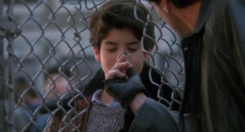Movie still from “Rocky V” (1990), directed by John G. Avildsen – A young boy with his hand over his mouth; Close Up shot, Over the shoulder angle