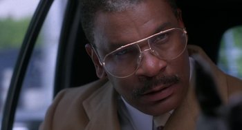 Movie still from “Rocky V” (1990), directed by John G. Avildsen – A person wearing a suit and glasses; Close Up shot, Low angle