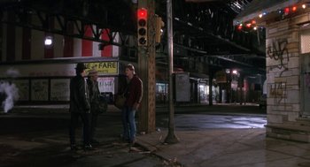 Movie still from “Rocky V” (1990), directed by John G. Avildsen – Two men standing on the side of the road at night; Wide shot, High angle