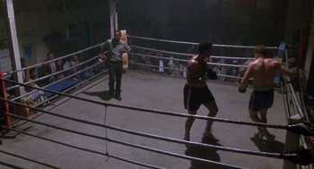 Movie still from “Rocky V” (1990), directed by John G. Avildsen – A man standing in the middle of a boxing ring; Wide shot, High angle