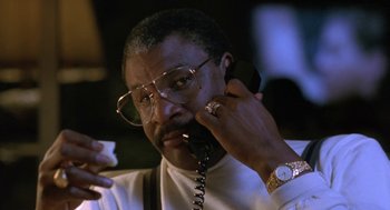 Movie still from “Rocky V” (1990), directed by John G. Avildsen – A man talking on a phone while holding a cigarette; Close Up shot, Low angle