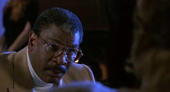 Movie still from “Rocky V” (1990), directed by John G. Avildsen – An older man wearing glasses looking at something in the distance; Close Up shot, Over the shoulder angle