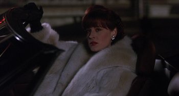 Movie still from “Rocky V” (1990), directed by John G. Avildsen – A woman with red hair and a white fur coat; Close Up shot, Over the shoulder angle