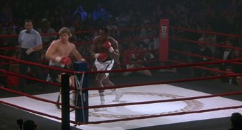 Movie still from “Rocky V” (1990), directed by John G. Avildsen – Two boxers in a boxing ring during a match; Wide shot, High angle