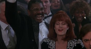 Movie still from “Rocky V” (1990), directed by John G. Avildsen – A man and a woman laughing in a crowd; Close Up shot, Low angle