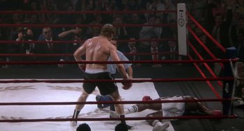 Movie still from “Rocky V” (1990), directed by John G. Avildsen – Two boxers in a boxing ring during a match; Wide shot, High angle