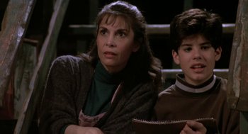 Movie still from “Rocky V” (1990), directed by John G. Avildsen – A woman sitting next to a young boy in front of stairs; Close Up shot, High angle