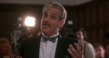 Movie still from “Rocky V” (1990), directed by John G. Avildsen – A man in a suit and a bow tie talking; Close Up shot, Low angle