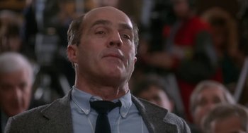 Movie still from “Rocky V” (1990), directed by John G. Avildsen – A man in a suit and tie looking upward; Close Up shot, Low angle