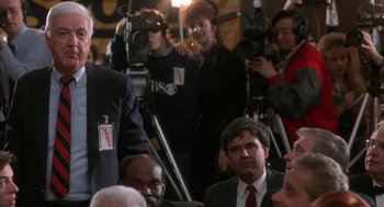 Movie still from “Rocky V” (1990), directed by John G. Avildsen – A group of people gathered around a camera; Medium shot, Over the shoulder angle