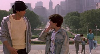 Movie still from “Rocky V” (1990), directed by John G. Avildsen – A man talking on a cell phone next to two other people; Medium shot, Over the shoulder angle