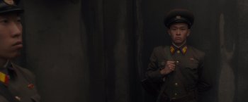 Movie still from “Salt” (2010), directed by Phillip Noyce – A man in a military uniform standing in front of a curtain; Medium shot, Low angle