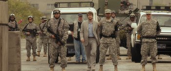 Movie still from “Salt” (2010), directed by Phillip Noyce – A group of men standing next to each other in front of a truck; Medium shot, Over the shoulder angle